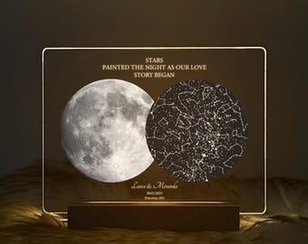 May include: A personalized night light with a moon and star map design. The text reads "STARS PAINTED THE NIGHT AS OUR LOVE STORY BEGAN" and includes the names "Lance & Miranda" and the date "18.03.2023" and location "Princeton, MO". The light sits on a wooden base.