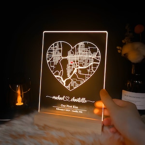 Pu&ograve; includere: Un cartello in acrilico bianco illuminato con una mappa di Seattle, Washington a forma di cuore. Il testo "michael &hearts; chantelle Our First Kiss February 5 2019 | Seattle, WA" &egrave; sotto la mappa.