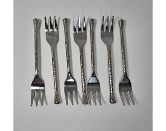 May include: Set of seven silver-toned cocktail forks with textured handles.