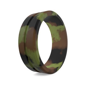 May include: A silicone ring with a camouflage pattern. The ring is black, brown, and green.