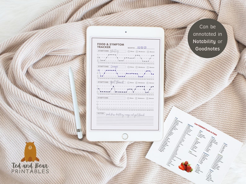 May include: A printable food and symptom tracker on a white tablet with a stylus. The tracker has sections for symptoms, notes, and a calendar. The tablet is on a white blanket. A separate sheet of paper with a list of low FODMAP foods is also visible.