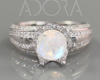 May include: A silver ring with a large, round, white moonstone center stone. The moonstone is surrounded by a halo of smaller, white stones. The band of the ring is also set with smaller, white stones.
