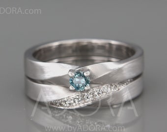 Op de afbeelding: Een zilveren trouwring met een blauwe edelsteen en een rij kleinere diamanten. De ring is gedraaid en heeft een geborstelde afwerking.