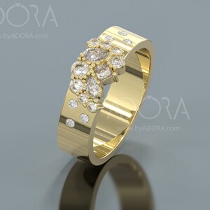 Pu&ograve; includere: Un anello con fascia in oro con un gruppo di piccoli diamanti incastonati in un design unico. L'anello &egrave; decorato con una fila di diamanti pi&ugrave; piccoli lungo la fascia.