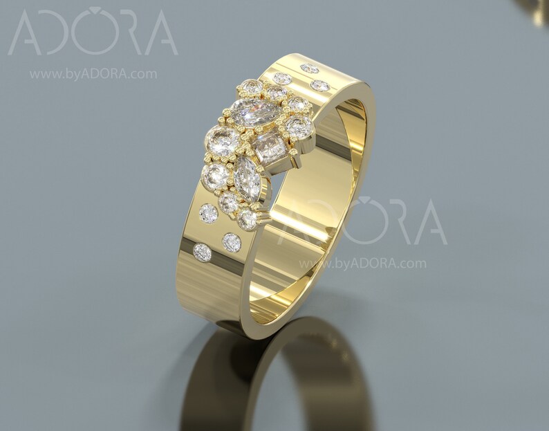 Pu&ograve; includere: Un anello con fascia in oro con un gruppo di piccoli diamanti incastonati in un design unico. L'anello &egrave; decorato con una fila di diamanti pi&ugrave; piccoli lungo la fascia.