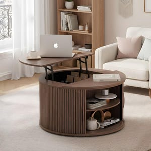 May include: A brown, lift-top coffee table with a laptop, coffee cup, and books. The table has a round base with vertical wood slats and open shelving. A white armchair with pink and blue pillows sits nearby.