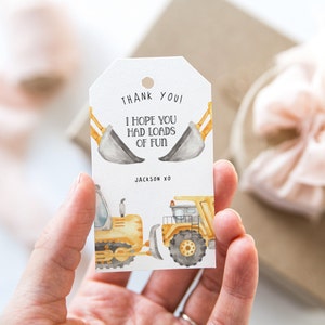 May include: A white thank you tag with a yellow and grey construction truck illustration. The text on the tag reads "Thank You! I hope you had loads of fun. Jackson XO".