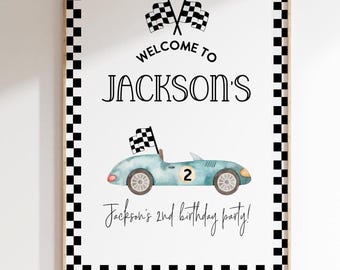 May include: A white welcome sign with a black checkered border. The sign says "Welcome to Jackson's" with a blue race car and checkered flags. The text at the bottom says "Jackson's 2nd birthday party!"