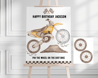 Puede incluir: Un juego imprimible para una fiesta de cumpleaños. El juego se llama "Pin the Wheel on the Dirt Bike". El juego presenta una moto de cross amarilla con un montículo de tierra marrón. Hay dos ruedas marrones para sujetar en la moto.
