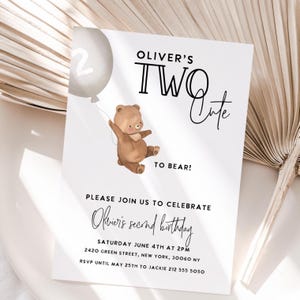 May include: White invitation card with the text "Oliver's Two Cute to Bear!" featuring a watercolor illustration of a brown teddy bear holding a gray balloon. The card announces Oliver's second birthday.