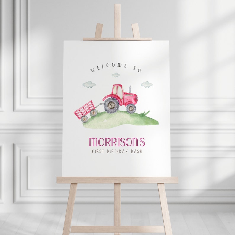 May include: Welcome to Morrison's First Birthday Bash sign featuring a red tractor with a wagon pulling behind it on a green grassy hill. The sign is on an easel.