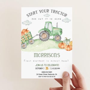Può includere: Un trattore verde che tira un carro pieno di zucche. Il trattore ha un pneumatico nero e una cabina verde. Il carro è marrone con un bordo bianco. Lo sfondo è un dipinto ad acquerello di un campo verde con nuvole. Il testo sull'invito recita: "Start your tractor and put it in gear. Morrison's First Birthday is almost here! Join us to celebrate! October 26 | 2-5:30 PM Creek Rd Farm 24 Green Street, Redondo, CA RSVP to Mom 310 555 55 55".