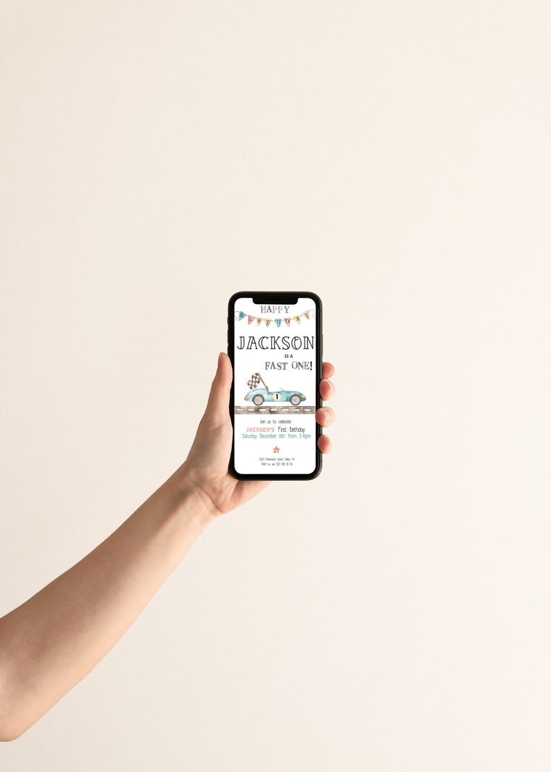 May include: A smartphone displaying a birthday invitation for a boy named Jackson. The invitation features a blue race car with a checkered flag and the text "Happy Jackson is a Fast One!"  Join us to celebrate Jackson's 1st birthday, Saturday December 10th from 3-5pm.