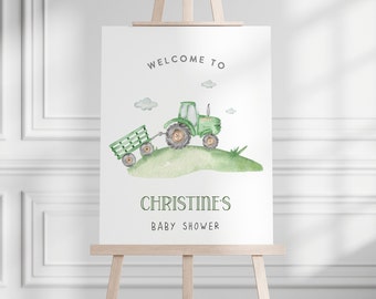 May include: Welcome to Christine's Baby Shower sign with a green tractor and trailer on a green hill with white clouds.