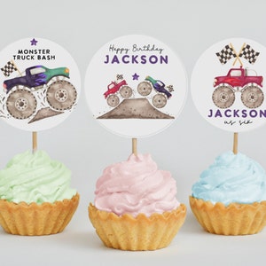 May include: Three round cupcake toppers featuring monster trucks with checkered flags. The toppers say "Monster Truck Bash", "Happy Birthday JACKSON" and "JACKSON is six".