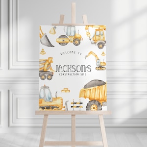 May include: A white sign with a yellow construction theme. The sign says "Welcome to Jackson's Construction Site" and features illustrations of construction vehicles, including a dump truck, bulldozer, excavator, and a cement mixer.