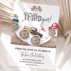 May include: White invitation card with a watercolor illustration of monster trucks racing on a dirt track. The text reads "Shifting into Third Gear!" and "Crush on over to celebrate!" with event details for Jackson's third birthday.