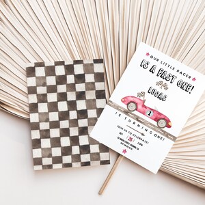 May include: A white invitation with a red race car and checkered flag design. The text reads "Our Little Racer is a Fast One! Lucas is Turning One!" and includes details for a birthday party.