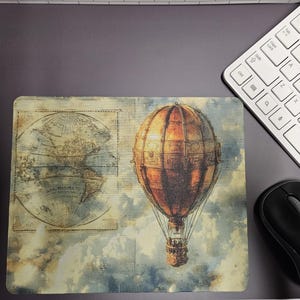 May include: A rectangular mousepad featuring a vintage hot air balloon design with a world map on the left. The balloon is brown and orange, set against a cloudy sky. A white keyboard and black mouse are also visible.