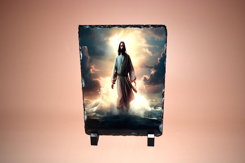May include: A rectangular slate plaque featuring an image of a figure in a white robe standing in water, with a bright light emanating from behind. The plaque is supported by a black stand.