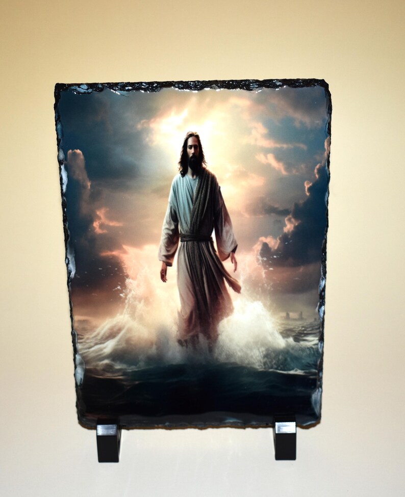 May include: A rectangular stone art piece depicting a figure in flowing robes walking on water. The background features a dramatic sky with clouds and a bright light source. The stone has a rough, dark edge.