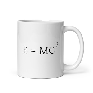 May include: White ceramic mug with a black inscription that reads "E = MC^2".
