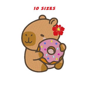 Può includere: Design ricamato di un orsetto dei cartoni animati che tiene in mano una ciambella rosa con zuccherini. L'orso ha un fiore rosso tra i capelli e il testo "10 TAGLIE" è in alto. Il disegno è su sfondo bianco.
