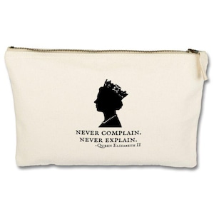 Op de afbeelding: Een beige canvas toilettas met een zwart silhouet van koningin Elizabeth II en de quote "Nooit klagen. Nooit uitleggen. -Koningin Elizabeth II"