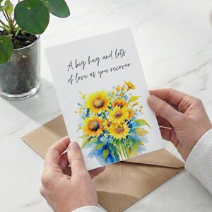 A person's hands holding a card with a floral design and a message about love.