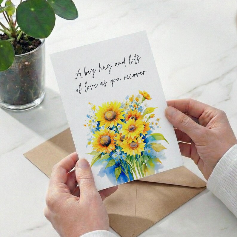 A person's hands holding a card with a floral design and a message about love.