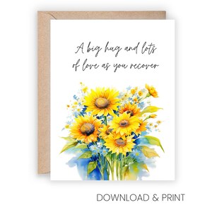A greeting card with a watercolor illustration of a bouquet of yellow sunflowers and blue flowers. The card has a message that reads "A big hug and lots of love as you recover".
