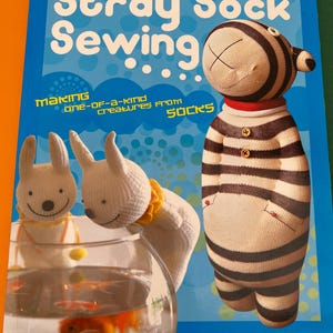 May include: A book titled "Stray Sock Sewing... Making one-of-a-kind creatures from socks" with a colourful background and a striped sock puppet on the cover.