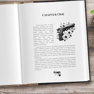 Op de afbeelding: Een open boek met de titel "Hoofdstuk één" gedrukt op de pagina. Een zwart-witte illustratie van een pistool met bloemen staat op de pagina. Het boek ligt op een houten oppervlak.