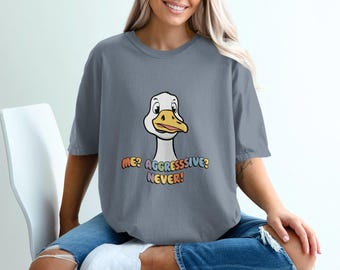 May include: A gray t-shirt with a cartoon goose and the text "ME? AGGRESSIVE? NEVER!" in rainbow colors.