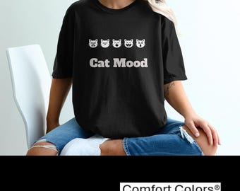 May include: Black t-shirt featuring a white graphic of five cats with different facial expressions. The text "Cat Mood" is printed below the cats.