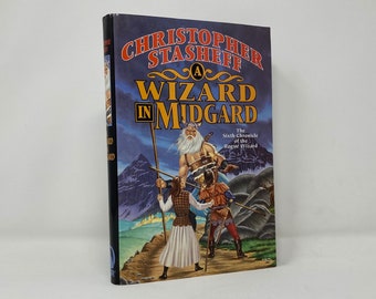 May include: A book cover with a fantasy illustration of a wizard with a long white beard, a young person in a white tunic, and a warrior in armor. The title of the book is "A Wizard in Midgard: The Sixth Chronicle of the Roger Zelazny", and the author is Christopher Stasheff.