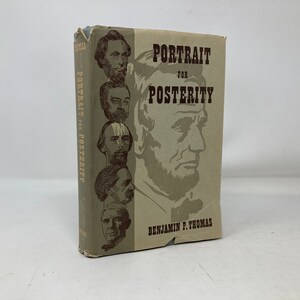 Może przedstawiać: Antyczna książka zatytułowana "Portret dla potomności" autorstwa Benjamina P. Thomasa. Okładka przedstawia portret Abrahama Lincolna i kilku innych postaci historycznych.