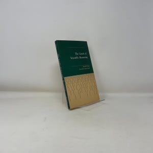 May include: A hardcover book titled "The Limits of Scientific Reasoning" by David Faust. The book has a dark green cover with white text and a tan lower section with vertical lines. The book is displayed on a clear acrylic stand.