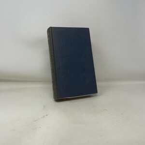 May include: A hardcover book with a dark blue cover and a spine with text. The book is standing upright on a white surface. The book's edges are a darker shade of blue. The book appears to be in good condition.