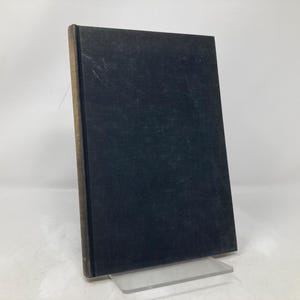 May include: A black hardcover book with a textured cover.