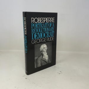 May include: A hardcover book titled "Robespierre: Portrait of a Revolutionary Democrat" by George Rude. The book has a black cover with white and blue text and a portrait of a man in a white wig.