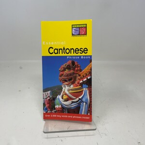 May include: A yellow and blue "Essential Cantonese Phrase Book" with a picture of a red and white statue. The book has the text "Over 2,000 key words and phrases inside!"