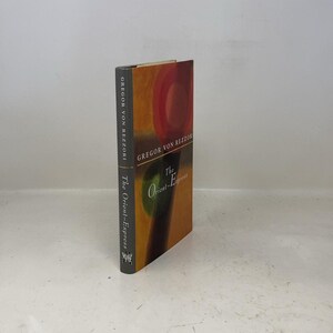 May include: A hardcover book titled "The Orient-Express" by Gregor von Rezzori. The book's cover features a colorful abstract design with red, orange, and green hues. The spine displays the author's name and the book's title in white text.
