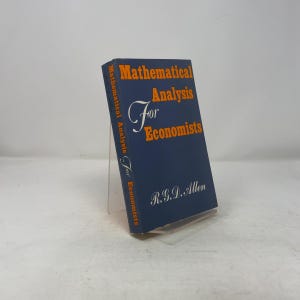 Może przedstawiać: Twarda oprawa książki zatytułowana "Mathematical Analysis For Economists" autorstwa R.G.D. Allena. Książka ma ciemnoniebieską okładkę z pomarańczowym napisem. Tytuł jest widoczny z przodu i na grzbiecie.
