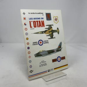 May include: A vintage book titled "LES AVIONS DE L'OTAN volume 1" with illustrations of military aircraft. The cover features a green and brown fighter jet and a gray jet. Text includes "ARMED FORCES" and "FORCES ARMEES".