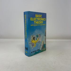 May include: A vintage book titled "Basic Electronics Theory" with a blue cover. The cover features yellow text and an illustration of a person working with computers and electronic equipment. The book is by Delton T. Horn.