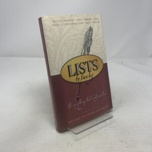 May include: A hardcover book titled "Lists to Live By" with a maroon cover and gold lettering. The cover features a feather illustration and the text "For everything that really matters." Keywords on the cover include Success, Friendship, and Love.