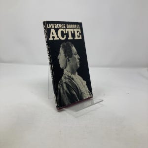 Puede incluir: Un libro de bolsillo en blanco y negro titulado "Acte" de Lawrence Durrell. La portada presenta una foto en blanco y negro de una persona con dos caras.
