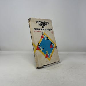 Peut inclure: Un manuel usagé intitulé "Introductory methods of numerical analysis" par S.S. Sastry. La couverture présente un motif de losange bleu avec des chiffres et des symboles. Le livre est soutenu par un support transparent.