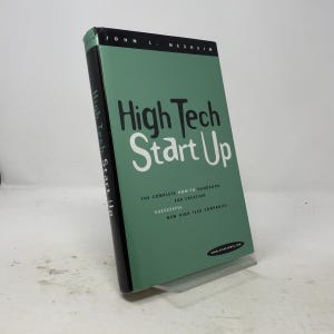 May include: A hardcover book titled High Tech Start Up by John L. Nesheim with a sage green cover and black spine. The front cover features the text High Tech Start Up, The Complete How-To Handbook For Creating Successful New High Tech Companies.